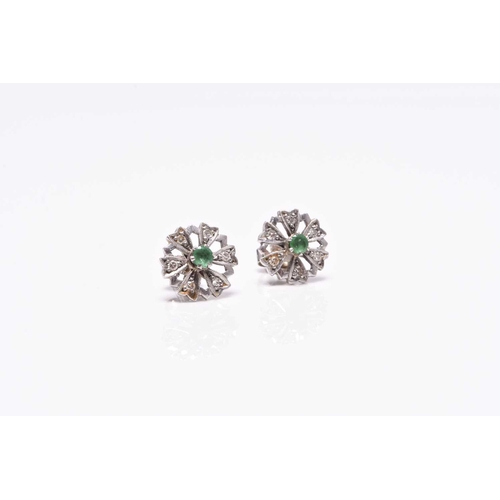 387 - A pair of emerald and diamond floral cluster earrings, each designed as a central round faceted emer... 