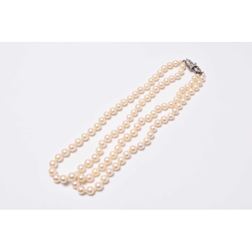 399 - A two strand uniform cultured pearl necklace with diamond set clasp, stamped '9ct' 'Lotus', 35cm lon... 