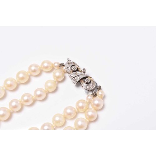 399 - A two strand uniform cultured pearl necklace with diamond set clasp, stamped '9ct' 'Lotus', 35cm lon... 