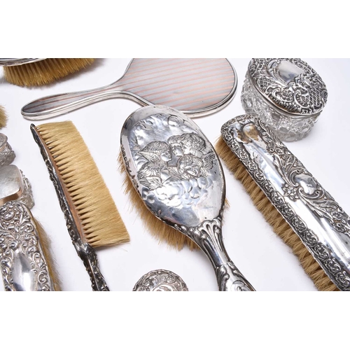54 - A collection of silver mounted dressing table wares, comprising; a hand mirror with rose metal embel... 