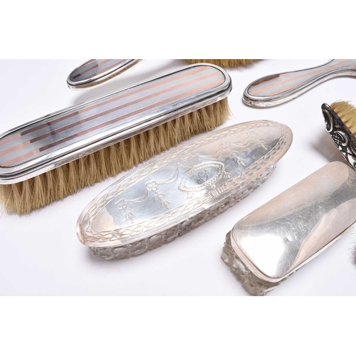 54 - A collection of silver mounted dressing table wares, comprising; a hand mirror with rose metal embel... 