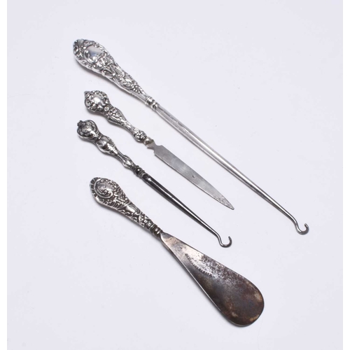 54 - A collection of silver mounted dressing table wares, comprising; a hand mirror with rose metal embel... 