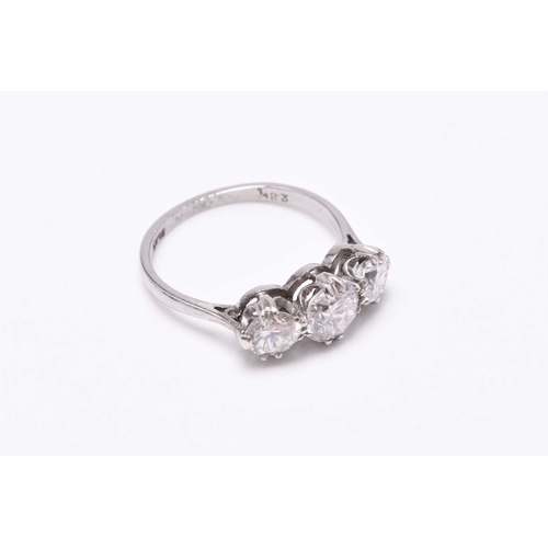 19 - A graduated three stone diamond ring, the brilliant cut diamonds claw set in white metal to white me... 