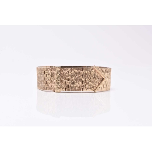 20 - A 9ct yellow gold stylised buckle bracelet, formed of textured brick links, the slide clasp with tex... 
