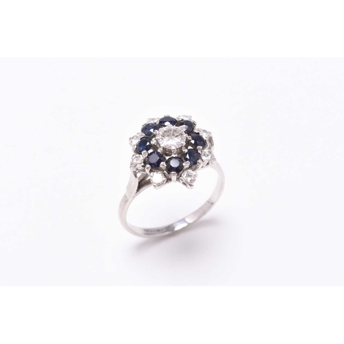 26 - A sapphire and diamond circular cluster ring, designed as a central brilliant cut diamond claw set w... 