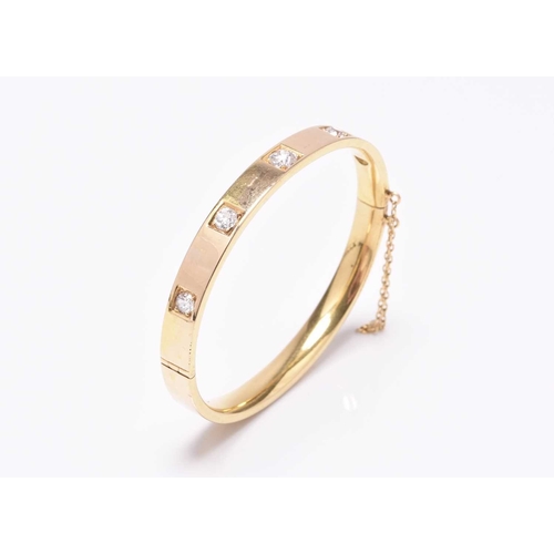 55 - A diamond set hinged bangle, the five old cut diamonds claw and box set in yellow metal with integra... 