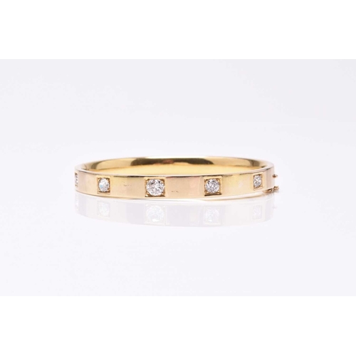 55 - A diamond set hinged bangle, the five old cut diamonds claw and box set in yellow metal with integra... 