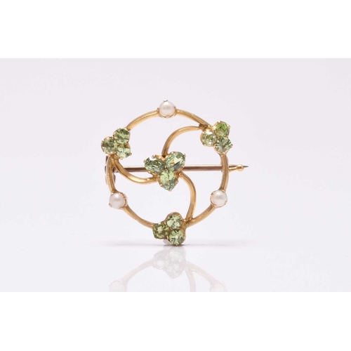 56 - A circular split pearl and green stone openwork brooch, designed as a central green stone cluster su... 