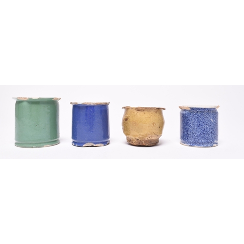 14 - Four ointment pots, early 19th century, comprising three tin-glaze examples, one green, one blue and... 