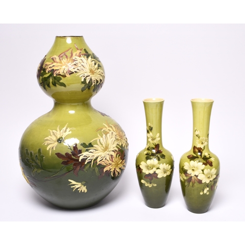 53 - A pair of Leeds Art pottery vases, circa 1890, of bottle form with slender necks, the shaded green g... 