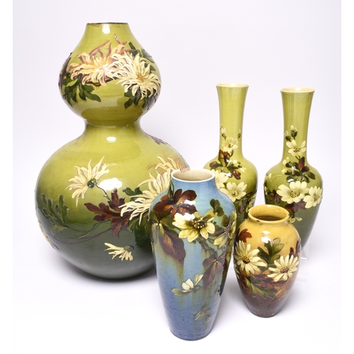 53 - A pair of Leeds Art pottery vases, circa 1890, of bottle form with slender necks, the shaded green g... 