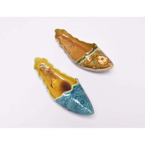 60 - Two Linthorpe art pottery wall pockets in the form of slippers, circa 1885, one with a turquoise ext... 