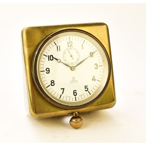 604 - An Omega brass-mounted car clock, retailed by Story of Barrow The white enamel dial with Arabic hour... 