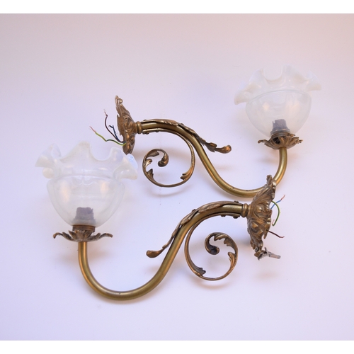 609 - Pair of gilt metal wall sconces with glass shades Of scroll form with acanthus leaf detail, the opal... 