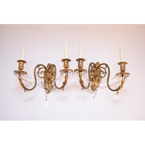 613 - A pair of Louis XVI style gilt metal and glass wall sconces Each with twin scroll branches set on ac... 