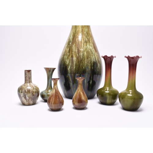 62 - A small group of art pottery, comprising three Linthorpe art pottery vases, circa 1890, covered in s... 