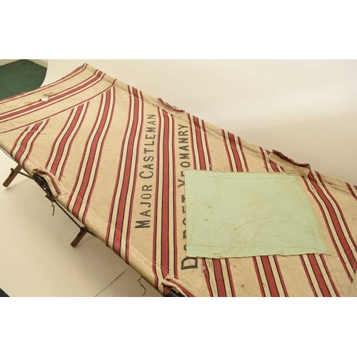 113 - A First World War British Army officer's folding campaign bed, with original red and white striped f... 