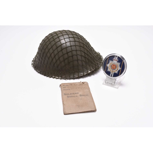 74 - An assembled group of militaria to include: A British Army MKIV helmet dated 1979, with exterior net... 