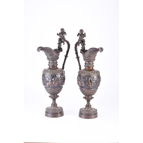 140 - A pair of ornamental bronze wine ewers, late 19th century Of amphora shape, the handles surmounted b... 