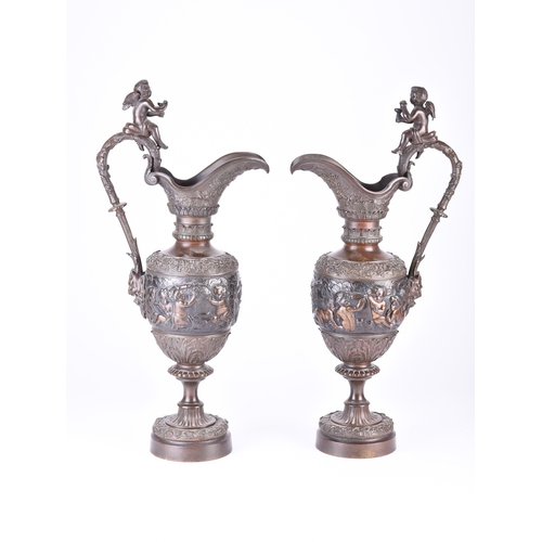 140 - A pair of ornamental bronze wine ewers, late 19th century Of amphora shape, the handles surmounted b... 