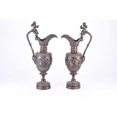 140 - A pair of ornamental bronze wine ewers, late 19th century Of amphora shape, the handles surmounted b... 