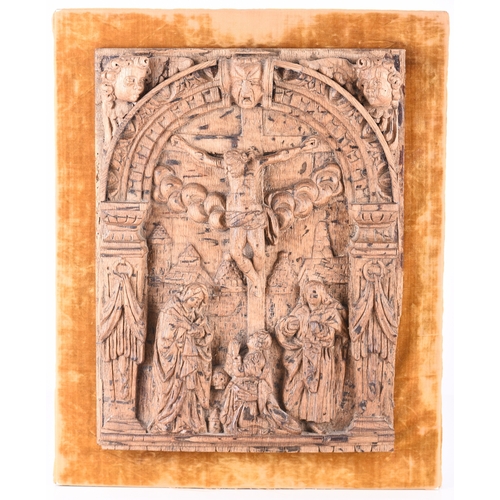 142 - A carved oak panel of The Crucifixion, possibly Bavarian 17th century The rectangular panel carved i... 