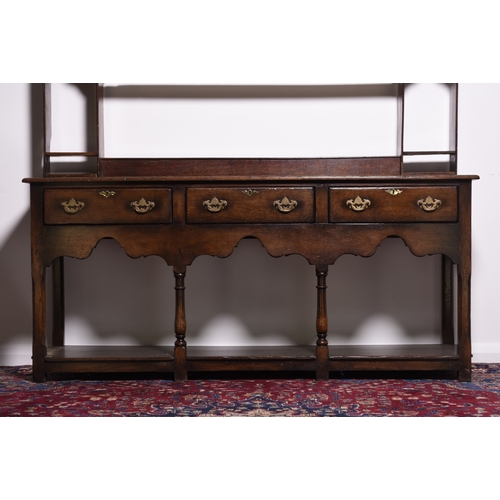 165 - A reproduction oak dresser and rack In the South Wales style The associated rack with reeded cornice... 