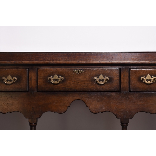 165 - A reproduction oak dresser and rack In the South Wales style The associated rack with reeded cornice... 