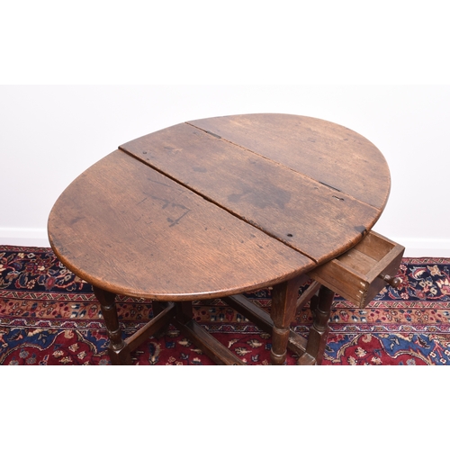 166 - A 17th century oak drop-leaf gateleg table The oval top above a single frieze drawer, raised on turn... 