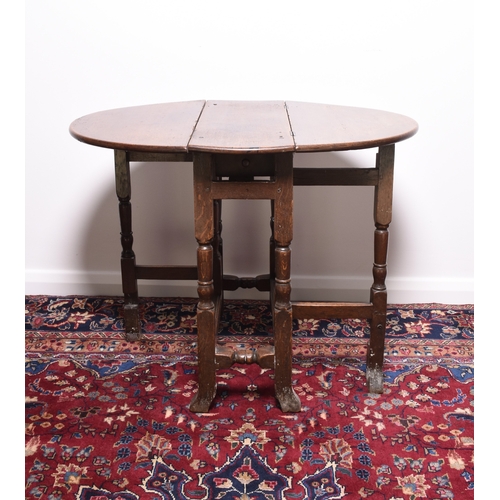 166 - A 17th century oak drop-leaf gateleg table The oval top above a single frieze drawer, raised on turn... 