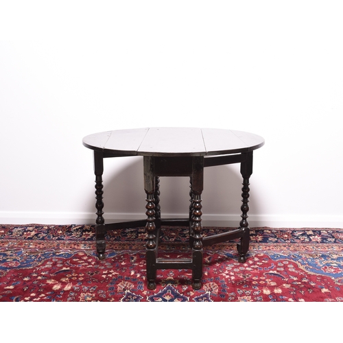 169 - A late 17th century oak gateleg drop-leaf table The oval top raised on elegantly turned supports, un... 