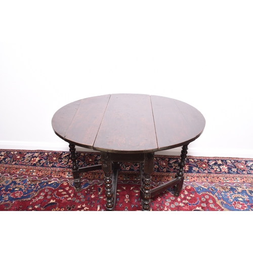 169 - A late 17th century oak gateleg drop-leaf table The oval top raised on elegantly turned supports, un... 