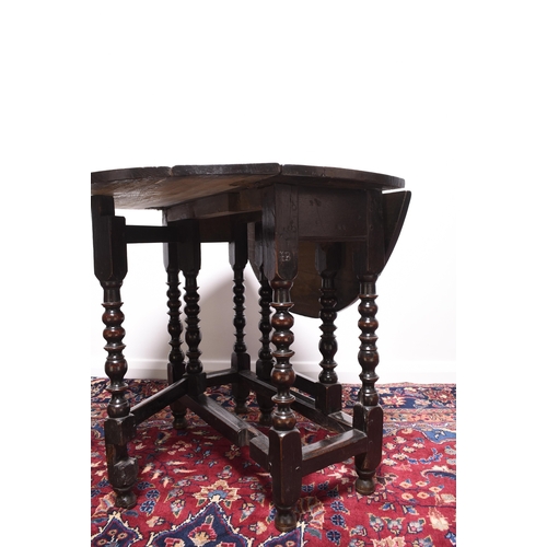 169 - A late 17th century oak gateleg drop-leaf table The oval top raised on elegantly turned supports, un... 