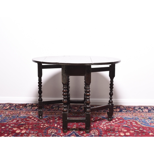 169 - A late 17th century oak gateleg drop-leaf table The oval top raised on elegantly turned supports, un... 