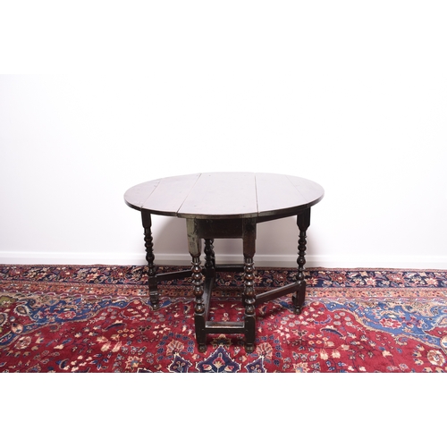 169 - A late 17th century oak gateleg drop-leaf table The oval top raised on elegantly turned supports, un... 