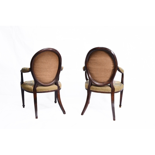 201 - A pair of Regency mahogany upholstered open armchairs The oval backs and padded arms over padded sea... 