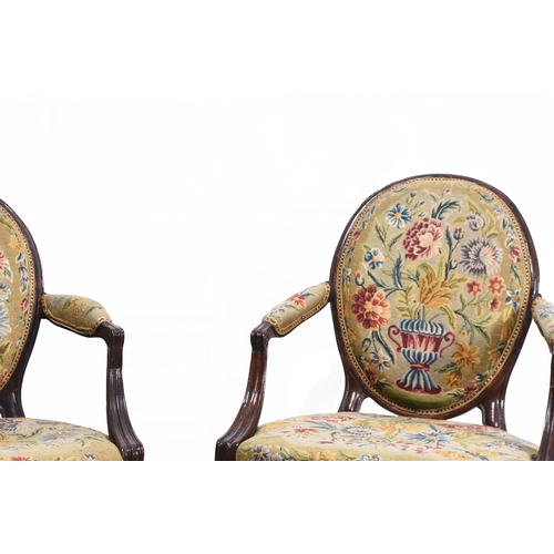 201 - A pair of Regency mahogany upholstered open armchairs The oval backs and padded arms over padded sea... 