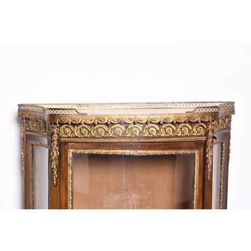 209 - A Louis XVI style gilt-metal mounted mahogany vitrine Of ogee form, the top with gilt metal gallery ... 