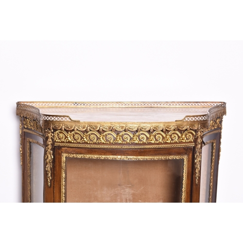 209 - A Louis XVI style gilt-metal mounted mahogany vitrine Of ogee form, the top with gilt metal gallery ... 