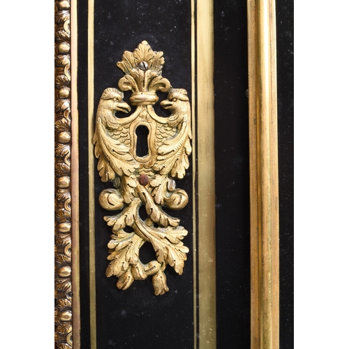 213 - A Louis XVI style ebonised and gilt-metal mounted pier cabinet With twin glazed doors enclosing thre... 