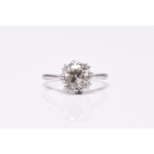 23 - A single stone diamond ring, the cushion cut diamond claw set in white metal to white metal shank, s... 