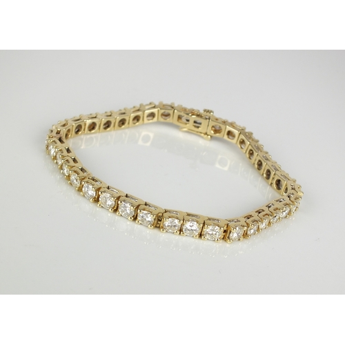 32 - A 9ct gold diamond set tennis bracelet, the thirty-six brilliant diamonds claw set in yellow gold, w... 