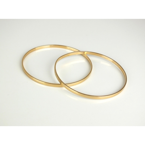 35 - A pair of yellow metal bangles, each stamped '14k 585', inner diameter approx 63mm, total weight app... 