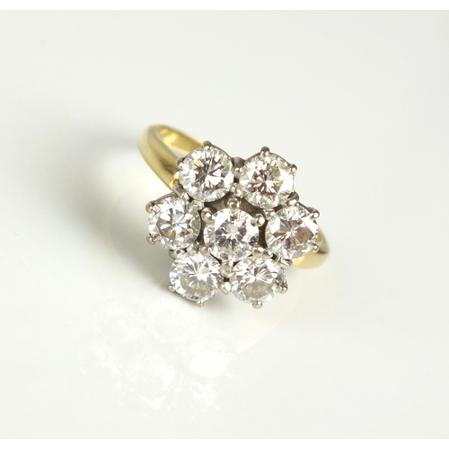 45 - A seven stone diamond floral cluster ring, the brilliant cut diamonds claw set in white metal to yel... 