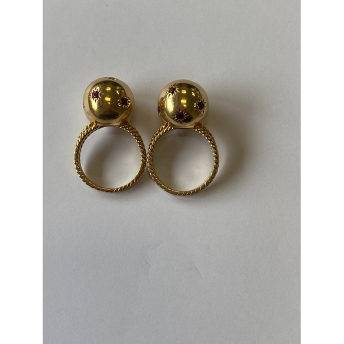 50 - A pair of ruby set orb rings, each designed as a yellow metal polished orb set with eight round face... 