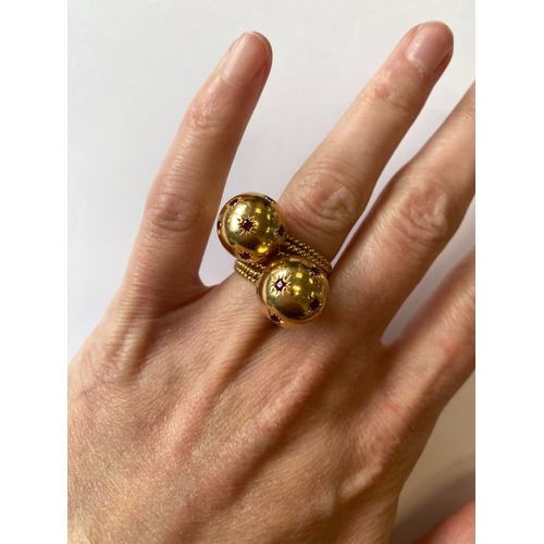 50 - A pair of ruby set orb rings, each designed as a yellow metal polished orb set with eight round face... 