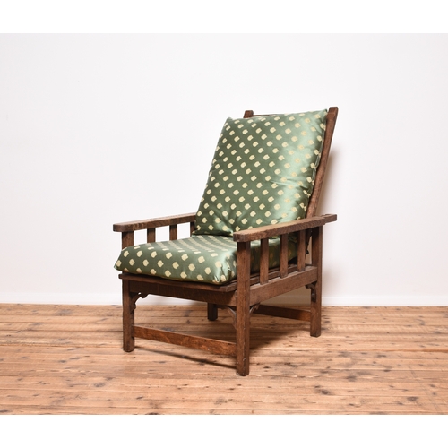 224 - An Arts & Crafts style oak Morris type reclining armchair Circa early 1900s, with loose cushions. 63... 