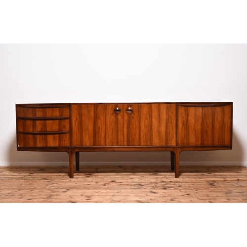 232 - A McIntosh rosewood veneered teak sideboard Having three drawers, twin cupboard doors enclosing a fi... 