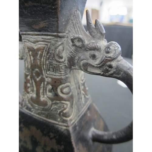 106 - A Chinese bronze archaistic Hu form vase, possibly Ming Dynasty With twin dragon head handles issuin... 