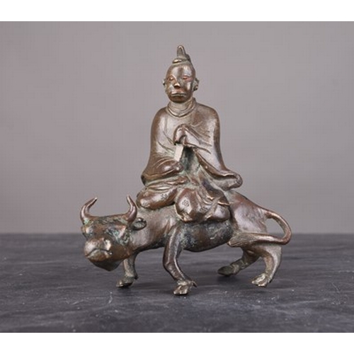 108 - A Chinese bronze figural scroll weight, Qing Dynasty Modelled as a lohan riding a buffalo. 8cm high